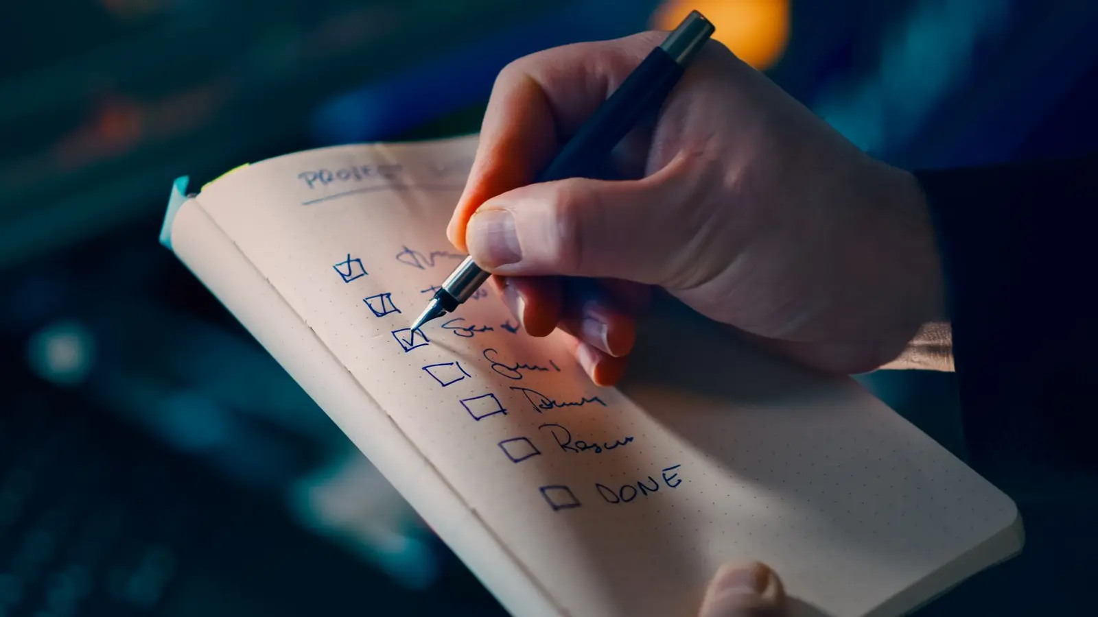 A hand checking off a project to-do list, one task at a time