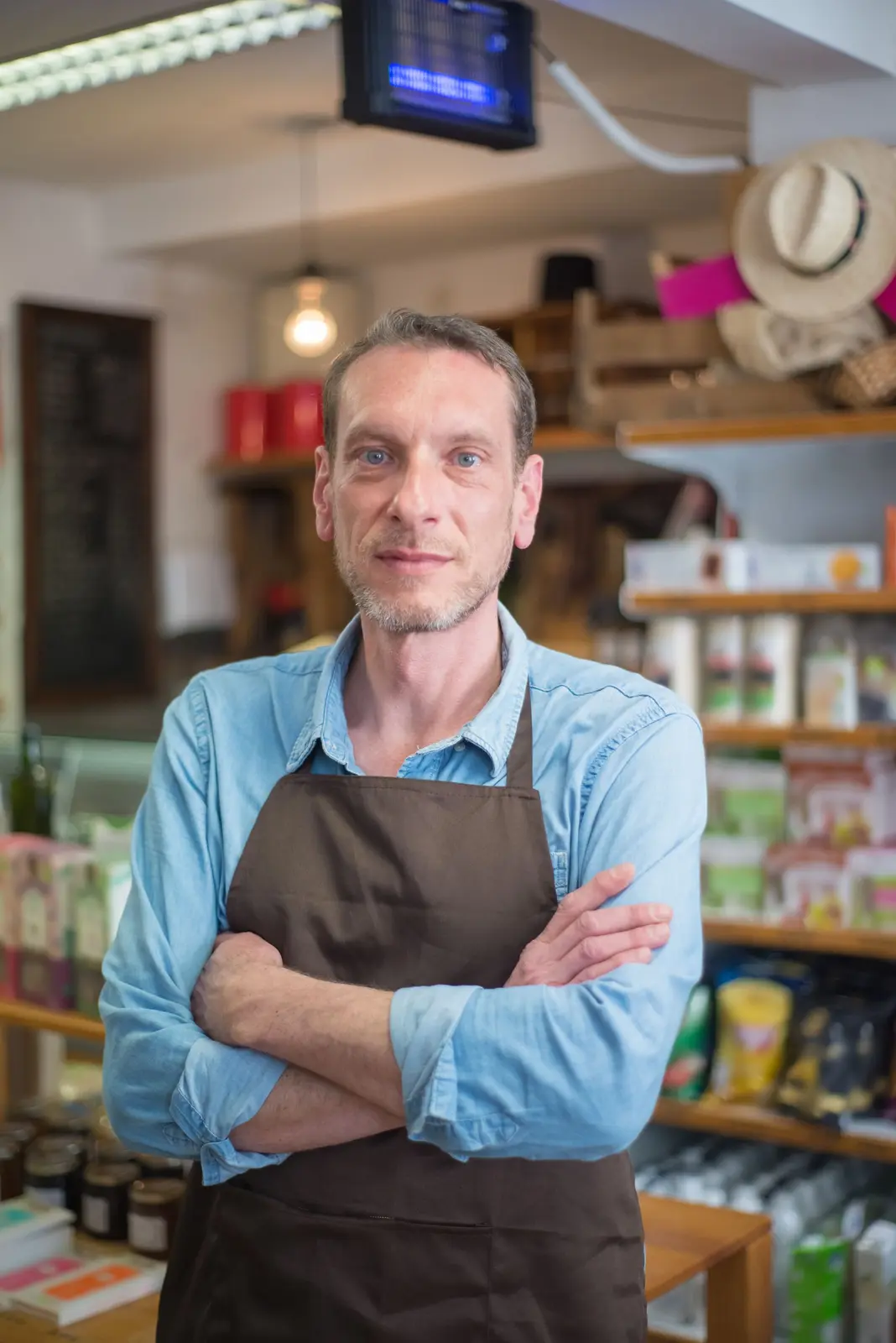 A shop owner standing confidently in his store