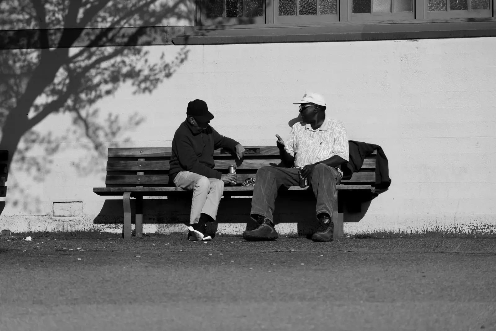 Two older men catching up on a park bench