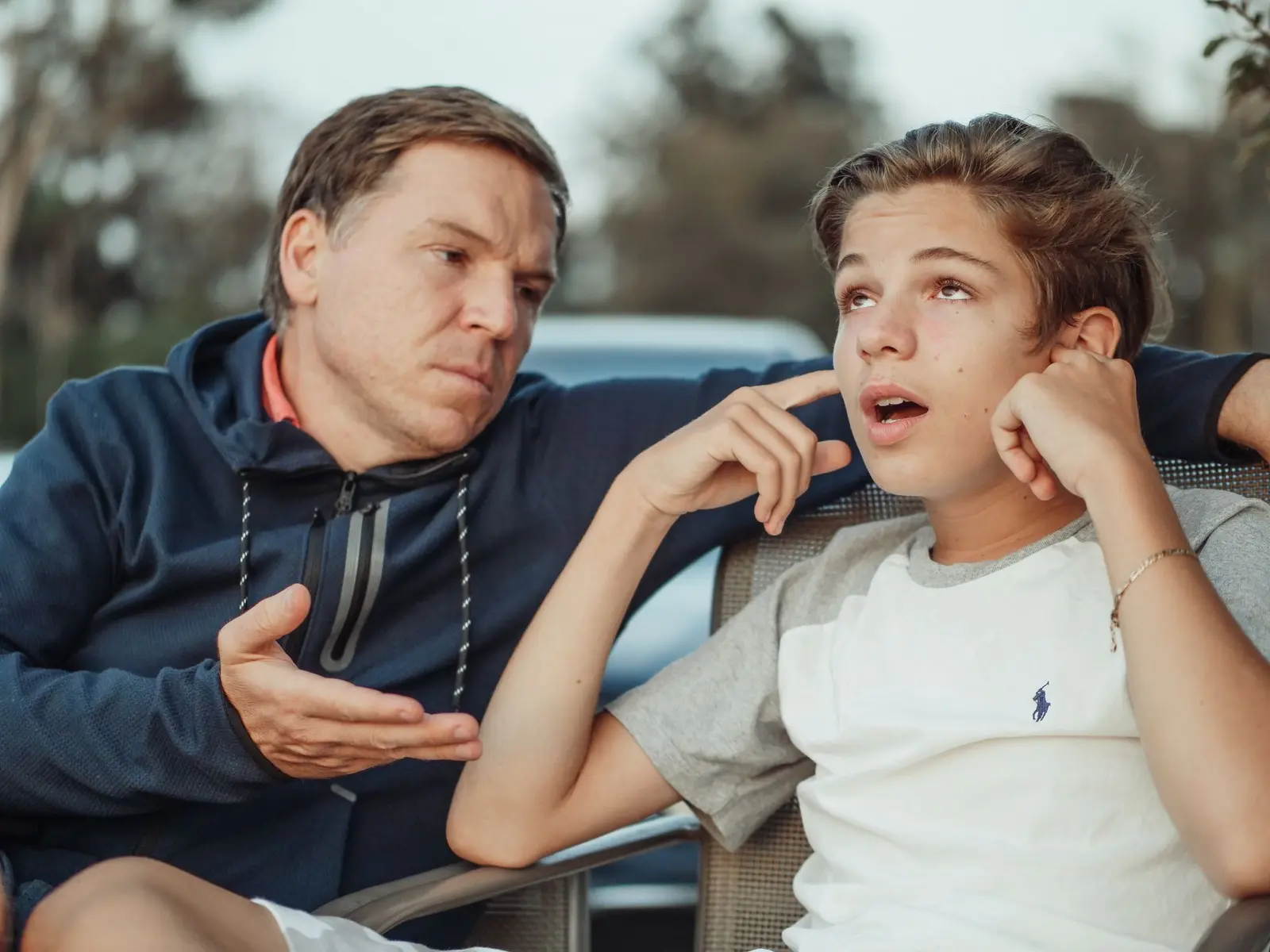 Father and son having a serious, honest conversation outdoors