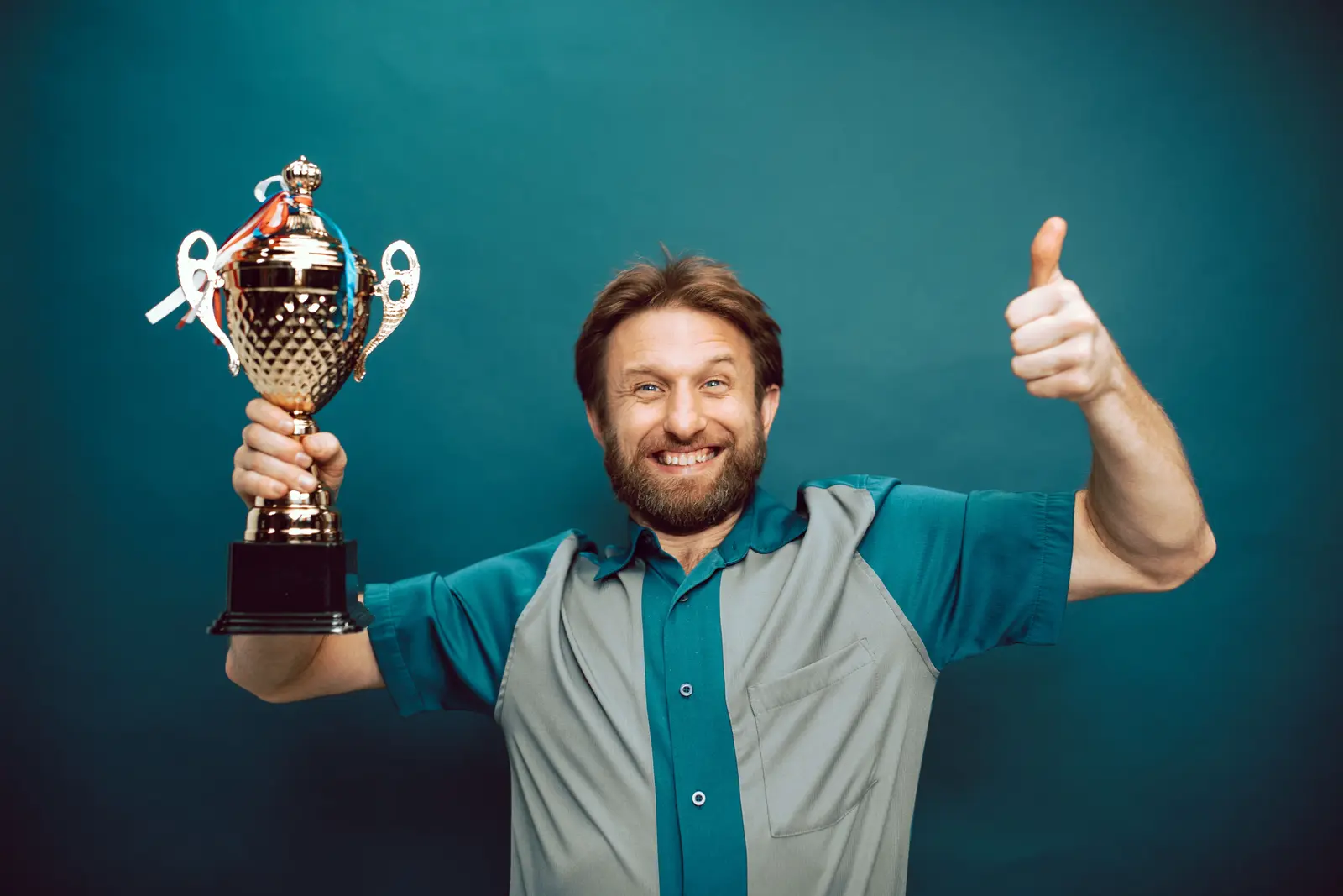 A man holding a trophy, celebrating a win