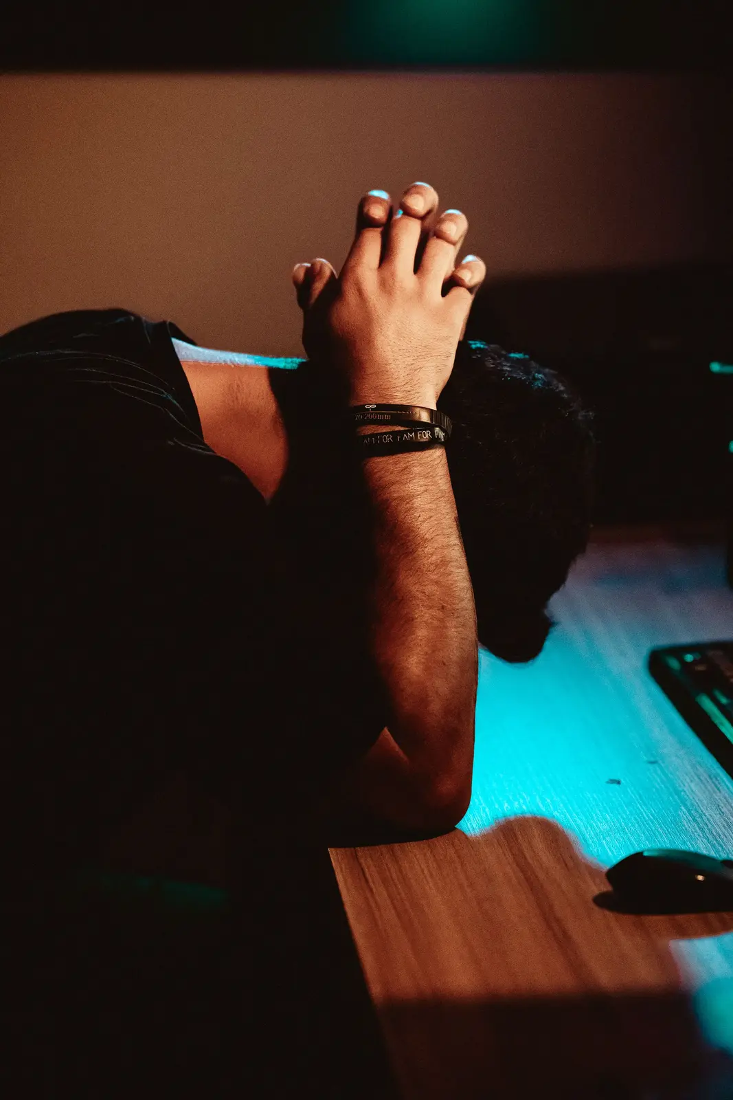A man resting his head on his desk, exhausted after a long day