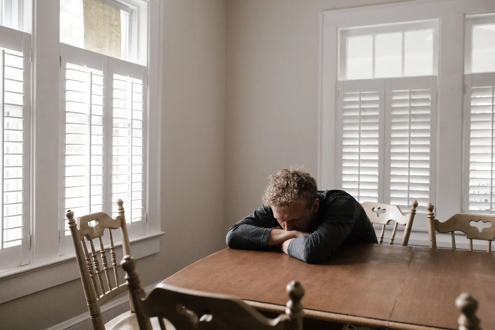 Man sitting quietly at a table, working through stress and self-reflection